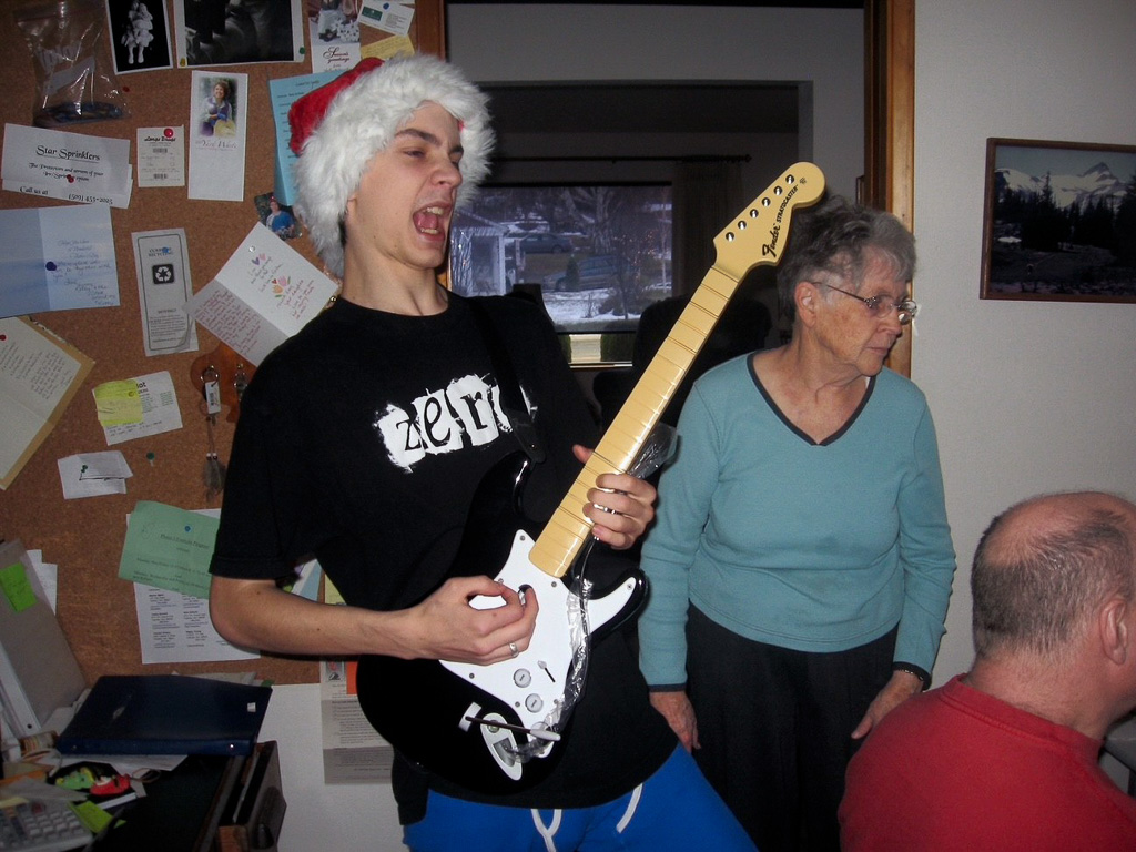 2007-12-25-Christmas-2007-Mom-successfully-focusing-on-Kelly-at-the-computer-while-grandson-Holland-is-strumming-away_r2026.jpg